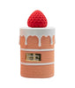 Perfume bottle with strawberry on top against a white background