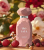 Pink perfume bottle labeled 'Safa' by Arabiyat with fruits and flowers in the background