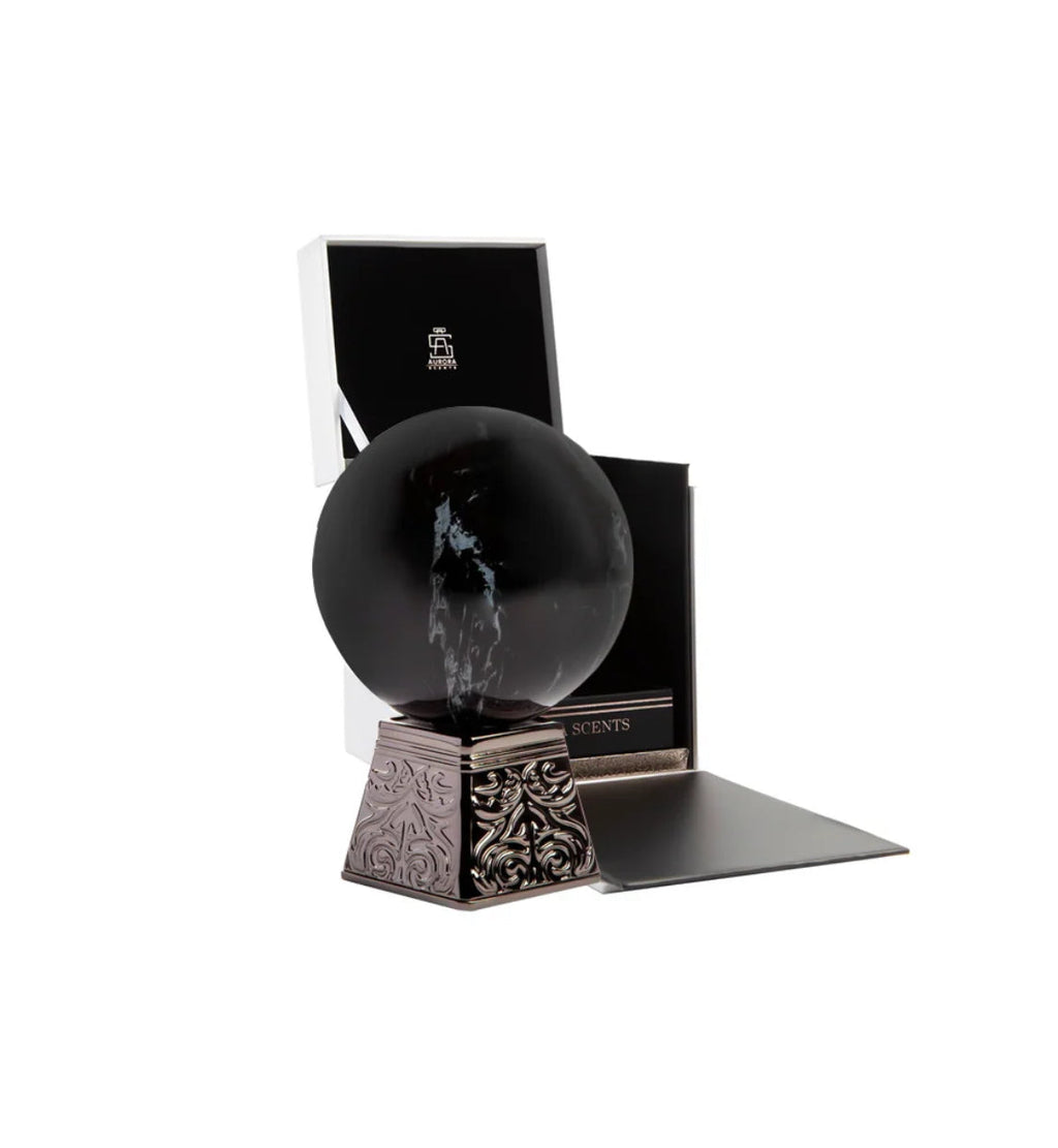 Decorative black sphere on a stand with a box in the background