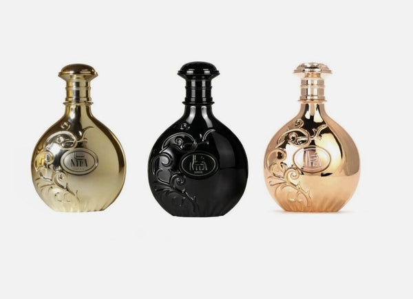 Three ornate bottles in gold, black, and bronze on a white background
