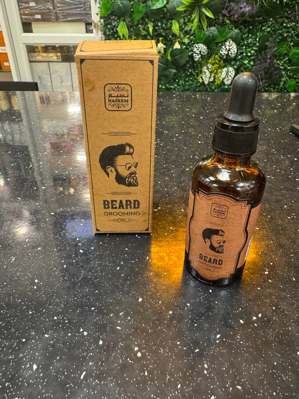 Bottle and box of 'Beard' grooming product on a reflective surface with greenery in the background