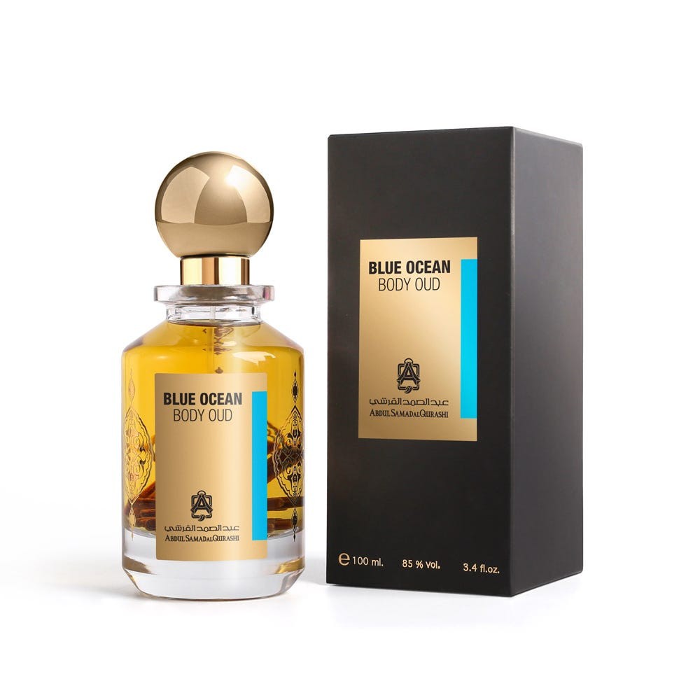 AbdulSamad AlQuraishi Blue Ocean Body Oud 100ml perfume bottle with gold cap beside its sleek black and gold packaging box. Ideal for men and women seeking a strong, musky, and woody fragrance.