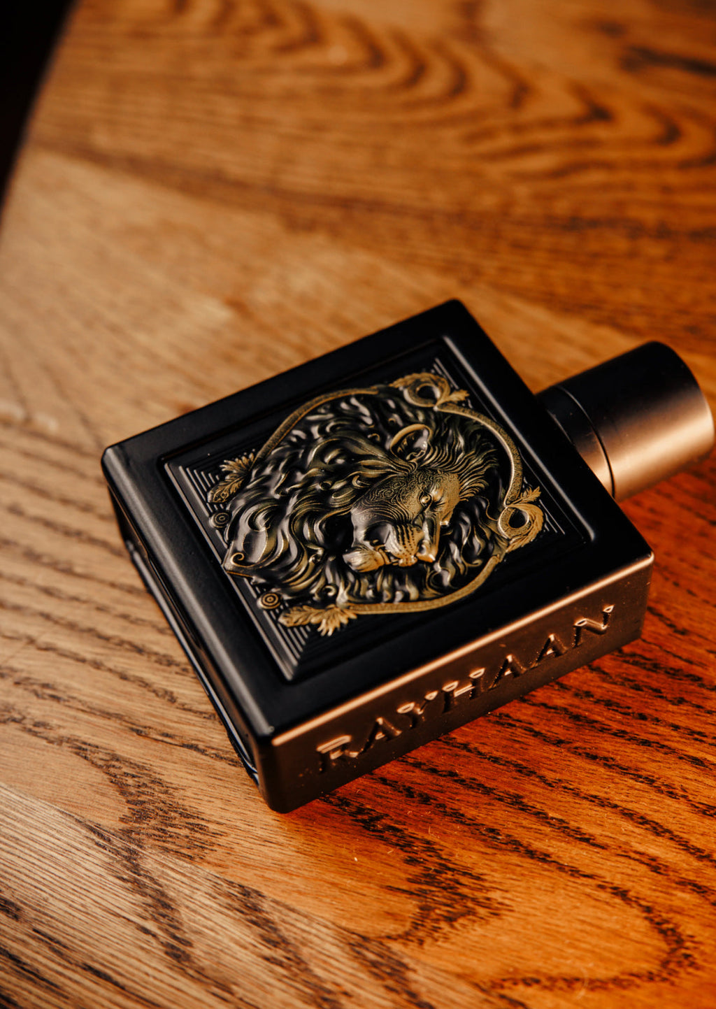 Decorative black and gold object with a lion emblem on a wooden surface
