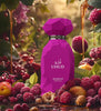 Purple perfume bottle labeled 'UHUD' surrounded by fruits and berries with a natural background