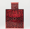 Decorative red metal box with intricate geometric pattern on a white background