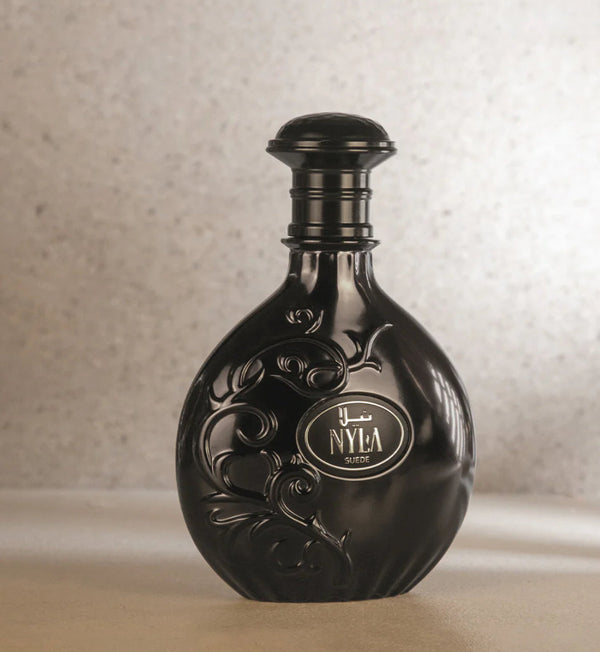 Elegant black Nyla Suede perfume bottle by Arabiyat Prestige featuring embossed floral design, perfect for warm, musky, and sweet unisex fragrance lovers.