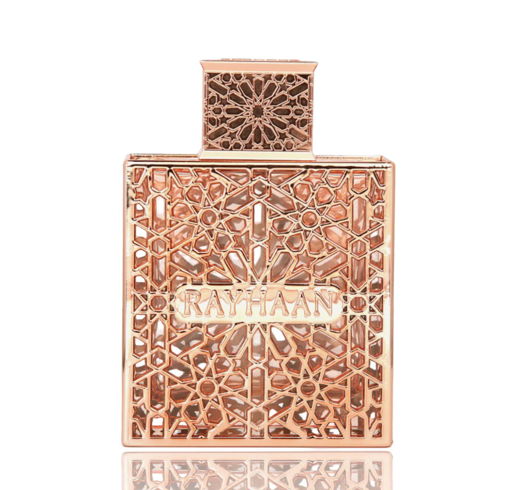 Rose gold perfume bottle with intricate design on a white background