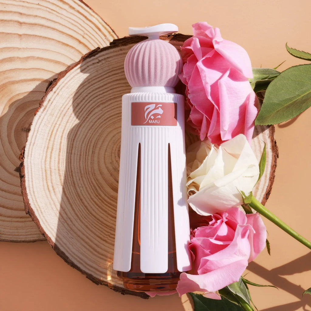 Ahmed Al Maghribi Marj Extrait de Parfum 60ML bottle styled with pink and white roses on a wooden background, showcasing its citrus floral musk fragrance.