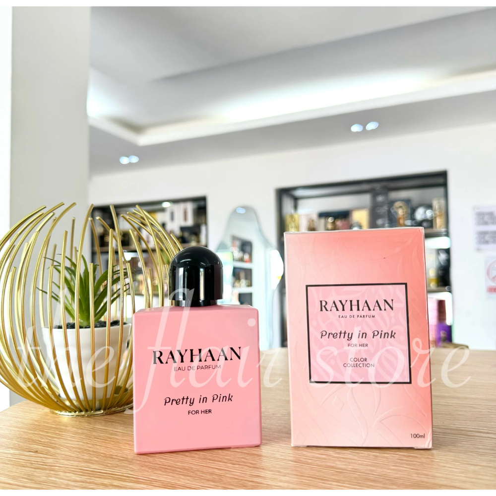 Rayhaan Pretty in Pink perfume bottle and packaging on a wooden surface with a blurred background.