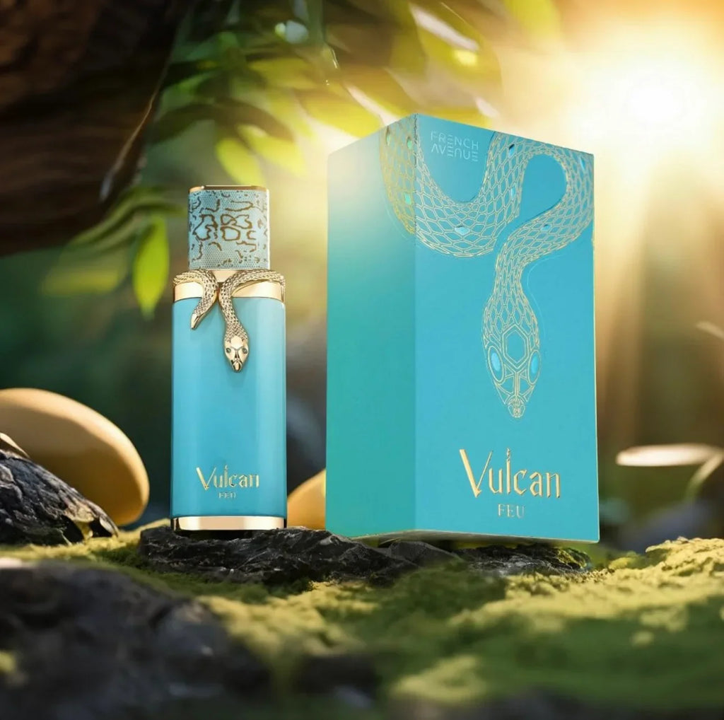 Vulcan Feu unisex luxury fragrance bottle and box with gold snake motif, displayed on rocks with sunlight and tropical greenery in the background.