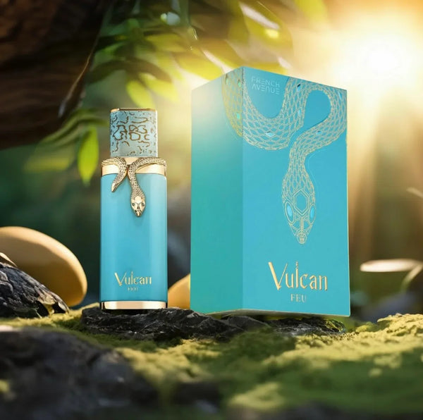 Vulcan Feu unisex luxury fragrance bottle and box with gold snake motif, displayed on rocks with sunlight and tropical greenery in the background.