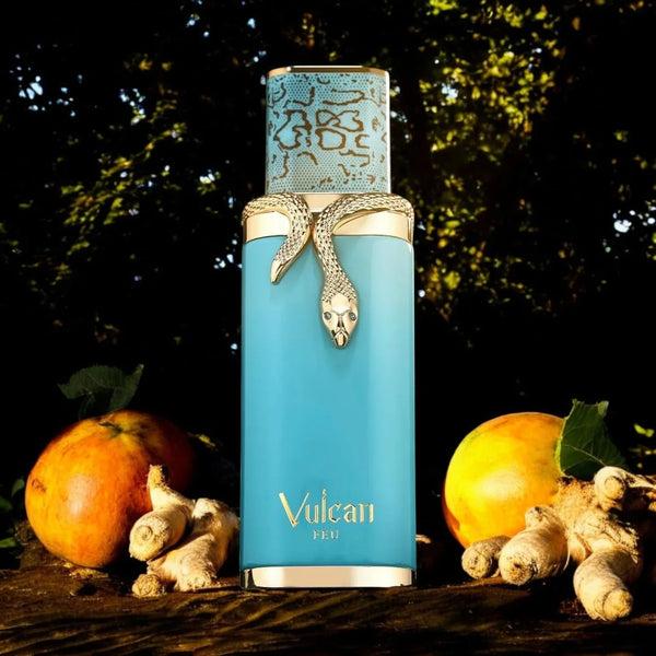 Vulcan Feu by French Avenue 100ml Eau de Parfum bottle in turquoise with gold snake design, placed among ginger roots and pomegranates in a forest setting.